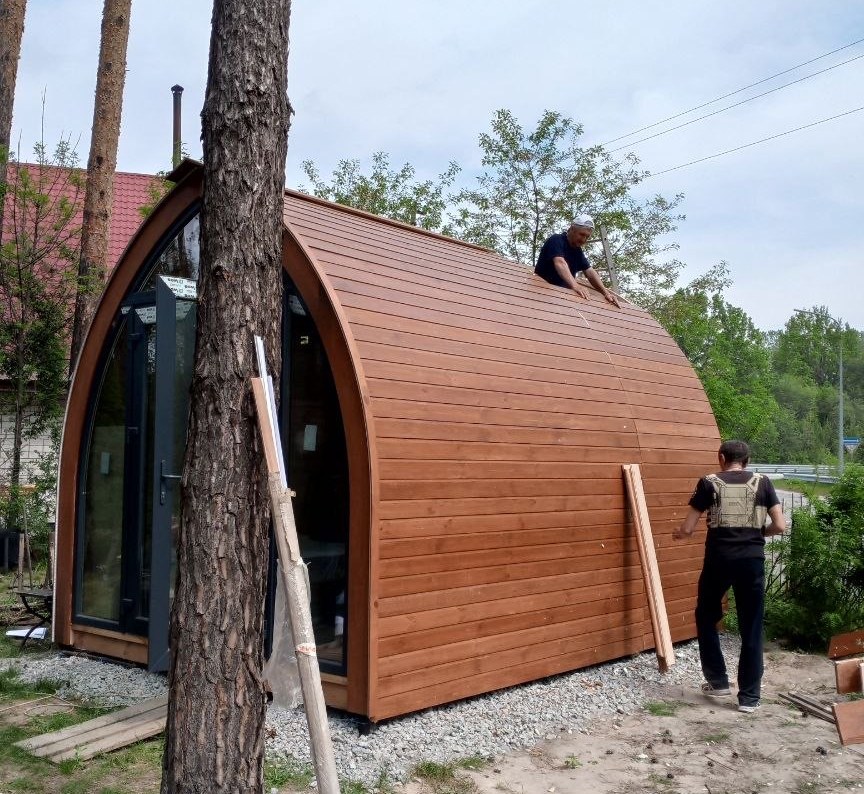 Монтаж фасадної дошки модуля GoodWoodHome на ділянці серед сосен